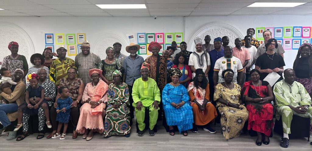 A large group photograph of everyone at the gathering, standing and seated in several rows at BCCEEP Hall.