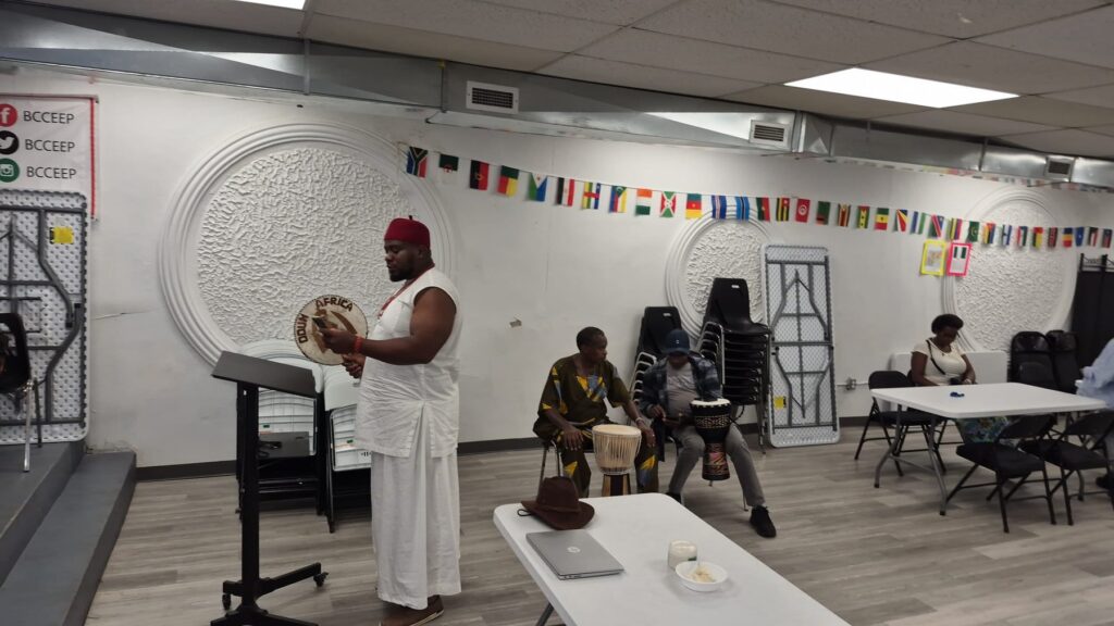A wide view of BCCEEP Hall with drums set on the floor to one side and guests at the tables beyond.