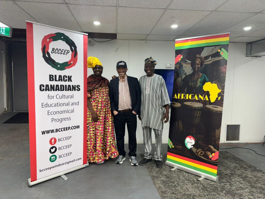 Three guests standing between the BCCEEP roll-up banner and the Africana banner at the BCCEEP Centre in Windsor
