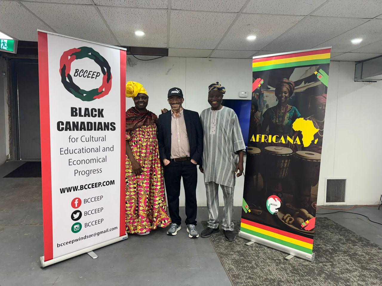 Three guests standing between the BCCEEP roll-up banner and the Africana banner at the BCCEEP Centre in Windsor