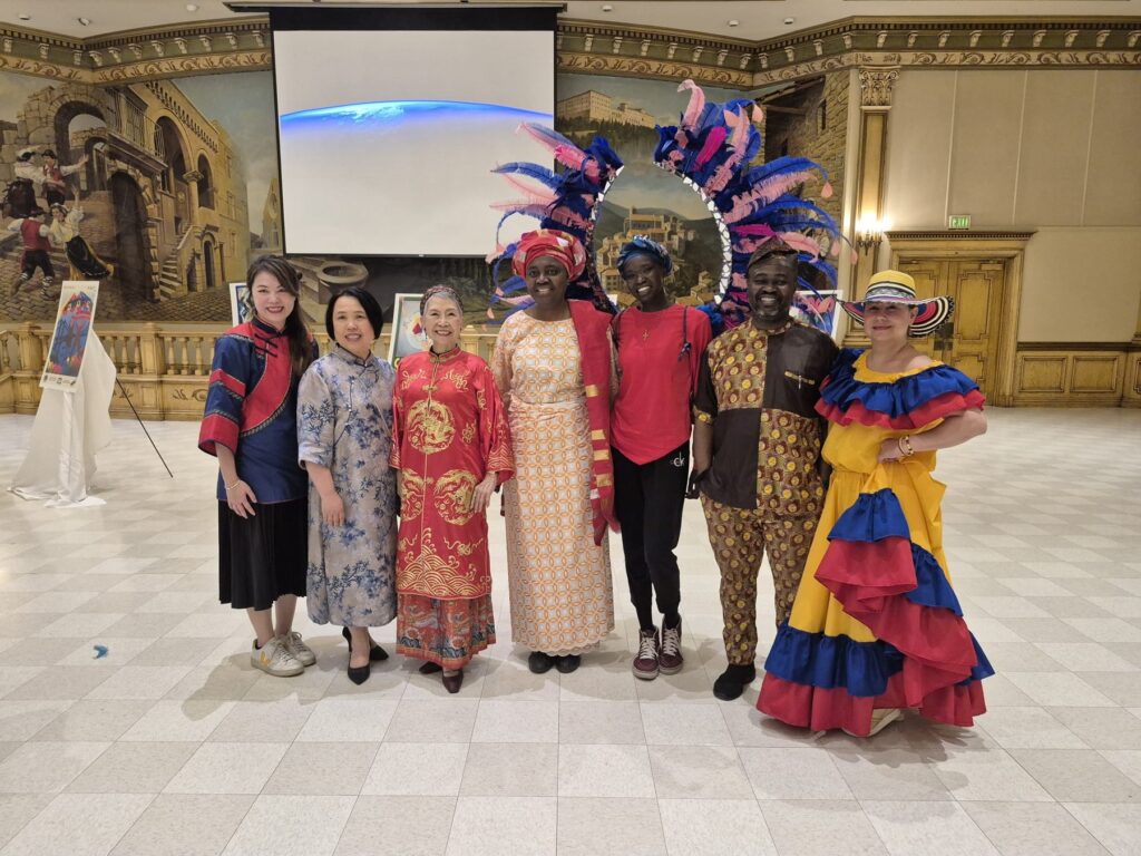 A line of guests in dress from many different countries standing together in the Ciociaro Club ballroom.