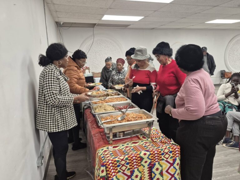 Guests serving themselves from chafing dishes set on a patterned cloth at the November gathering.